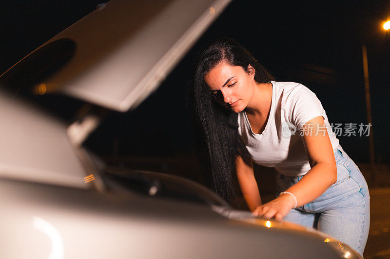 一位年轻女子在路边修汽车