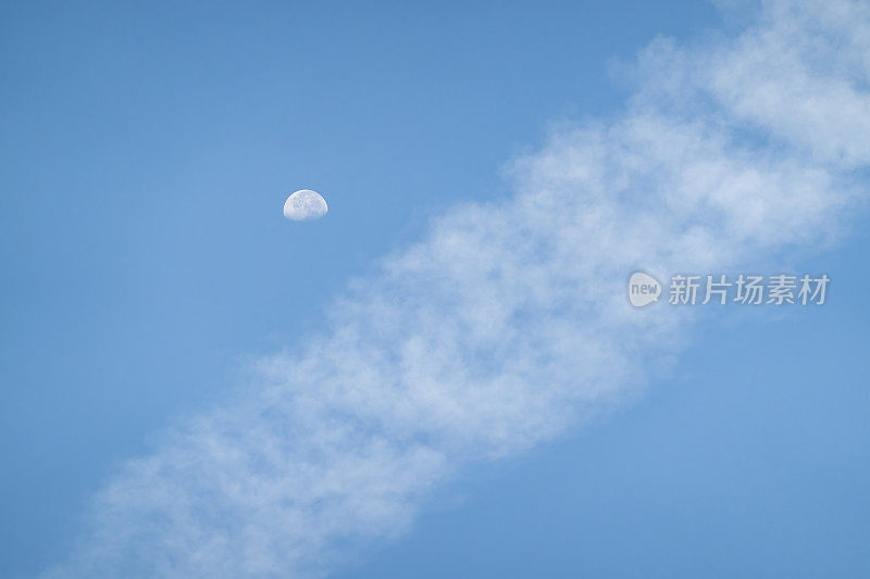 月亮从飞机航迹的云层上升起