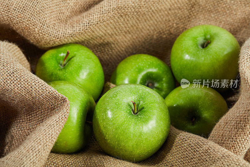 新鲜的绿苹果在织物上