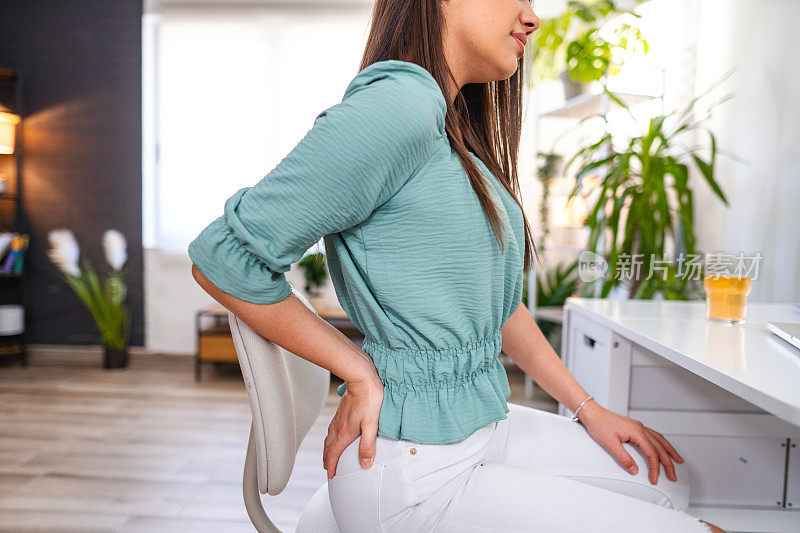 年轻女性在家工作时背部疼痛
