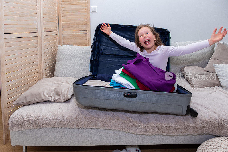 白种人女孩7岁，爬进一个大行李箱，女孩很高兴