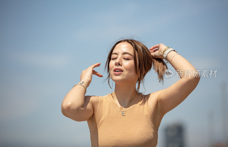 年轻女子正在外面享受夏天的阳光。