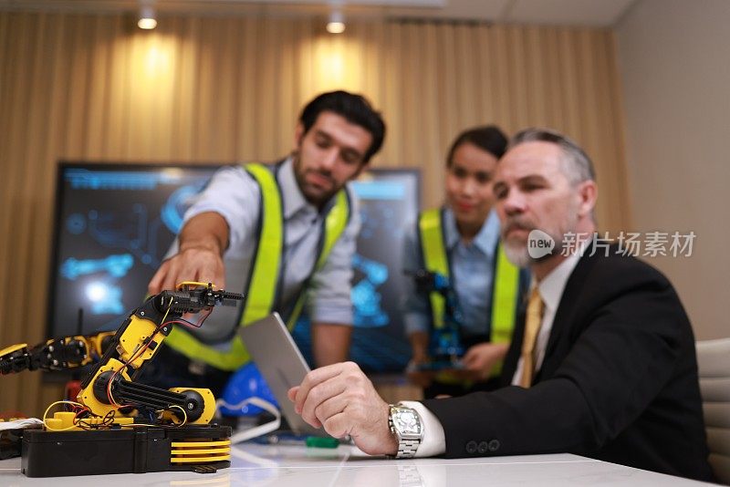 一群熟练的机器人工程师仔细检查了机械臂的原型，目的是将其提交给行政长官。