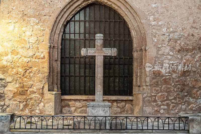 教堂窗户前的中世纪石制十字架。