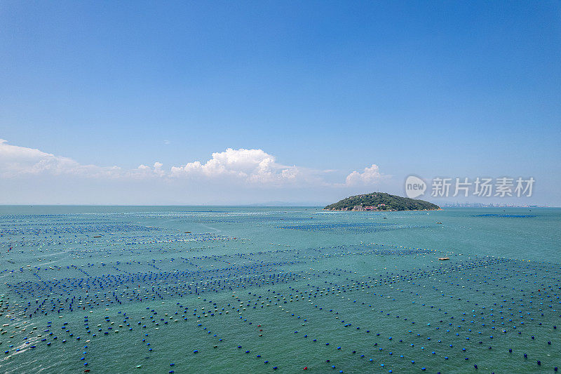 鸟瞰海中的小岛和海上漂浮的水产养殖场