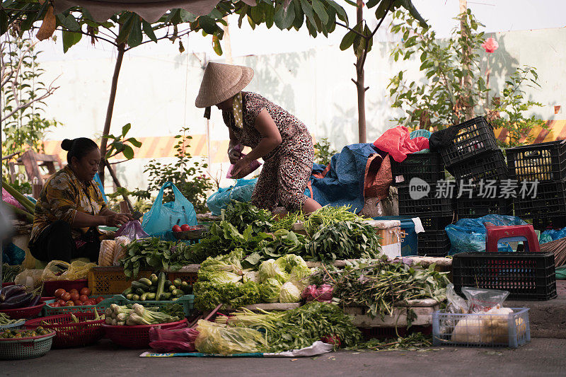 越南胡志明街市上卖蔬菜的妇女