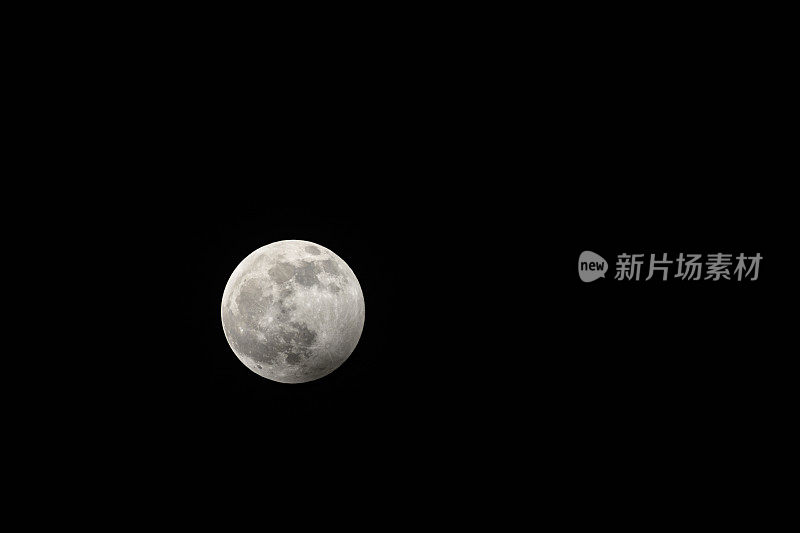 满月在黑暗的冬夜与清晰可见的月球表面期间，一个微弱的偏食