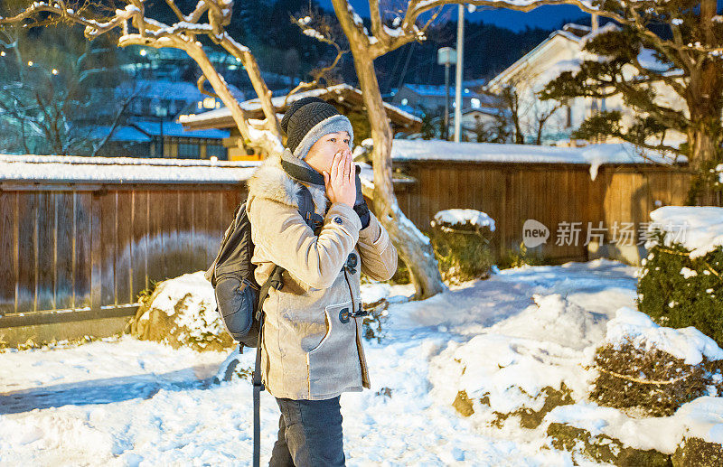 英俊的亚洲男人在公园与白雪冬天在高山城市，日本