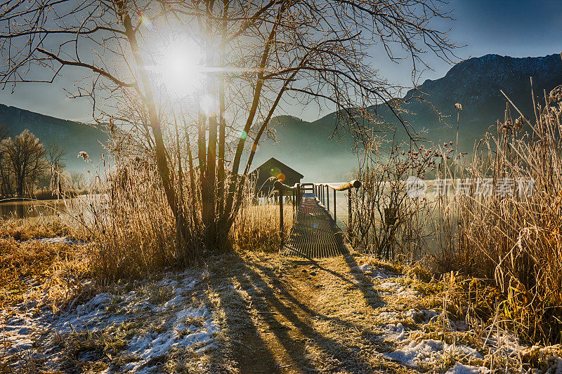 在一个有雾和初升的太阳的霜冻的早晨，山湖上的船屋