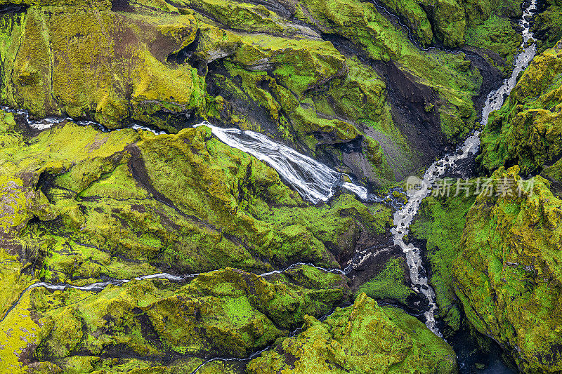 冰岛一条流淌的小河切割出的翠绿色峡谷。从直升机上高高举起的