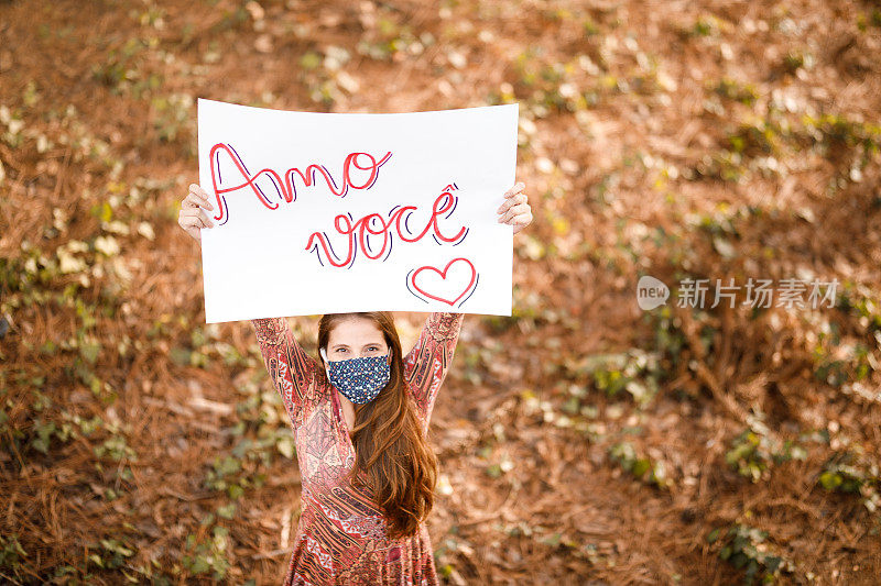 幸福的女人拿着一张爱你的海报