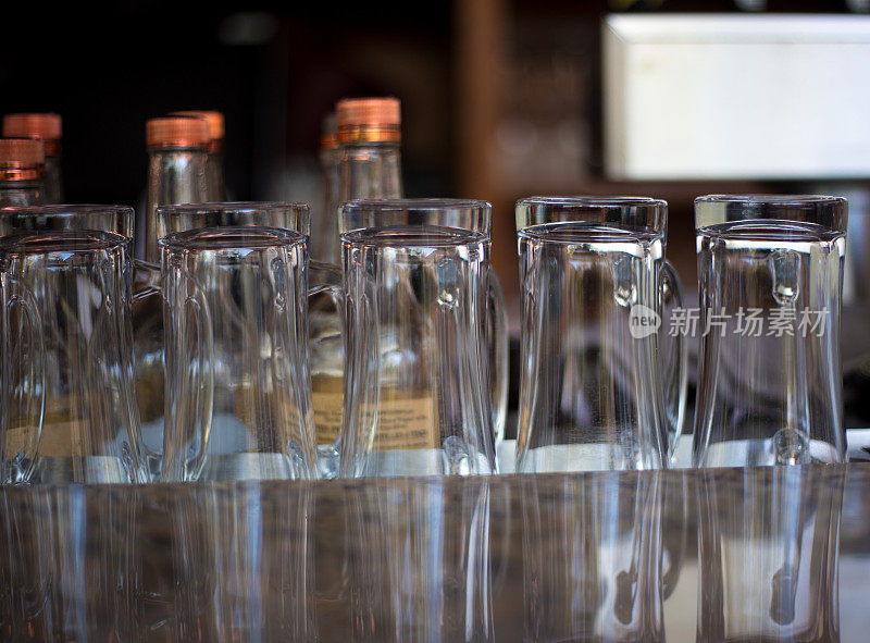 吧台上玻璃和瓶子排成一排