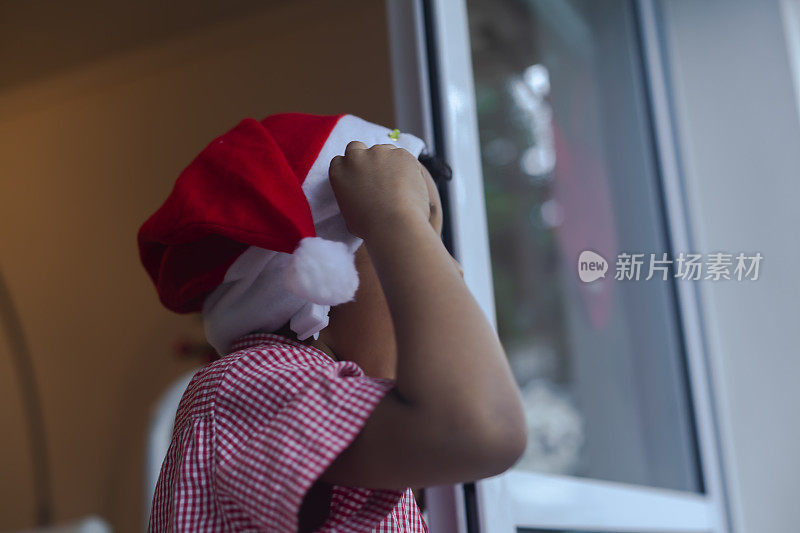 在圣诞节庆祝活动中，年轻的黑人男孩戴上了圣诞老人的帽子