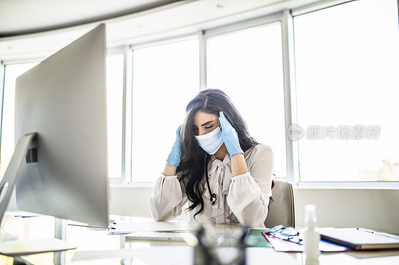 疲惫的女医生在办公室工作时表现出冠状病毒症状