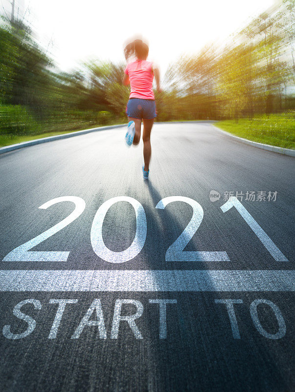 一名年轻的亚洲女子在公园里慢跑，地上还有2021号