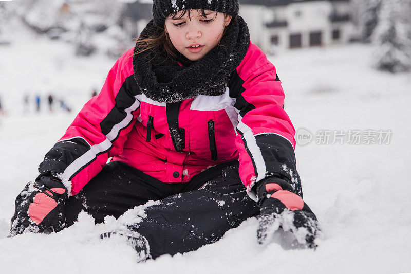 严肃的小女孩在雪中玩耍