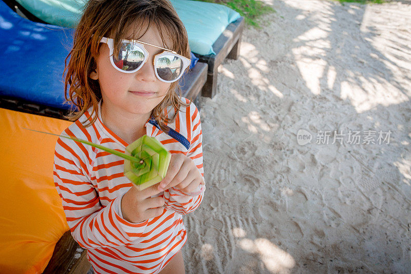 在海滩度假的孩子持有纪念品棕榈树玫瑰