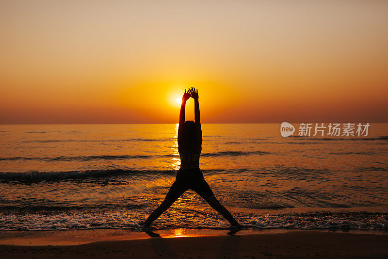 年轻女子在海滩上练习拜日式