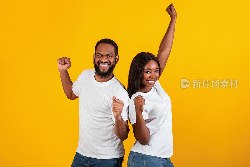 情绪激动的黑人夫妇举起拳头庆祝胜利