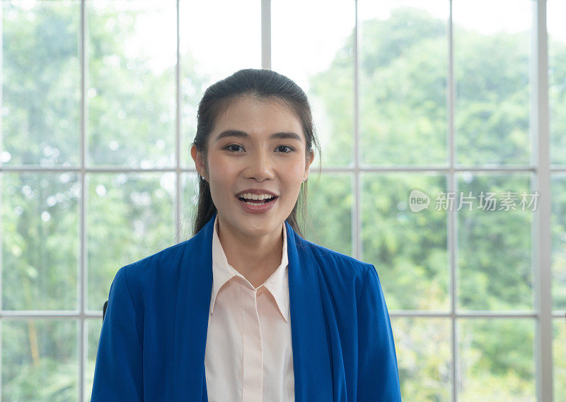 微笑的亚洲商业妇女肖像，泰国人在家工作，与她的同事在网络摄像头组视频电话会议在线隔离在冠状病毒大流行。