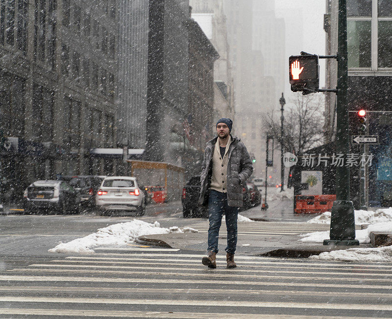 一名年轻游客，在一场大雪中穿过曼哈顿的街道