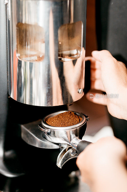 咖啡师从手动研磨机中研磨咖啡豆