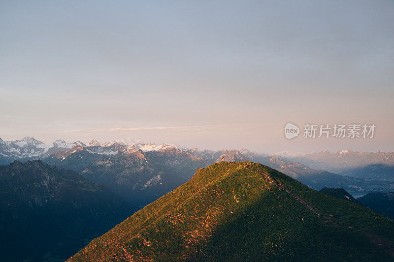 从郁郁葱葱的山脊向下眺望远处的山峰