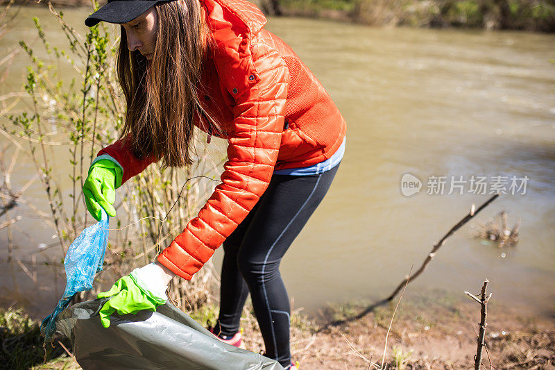 一位年轻的妇女自愿清扫河岸