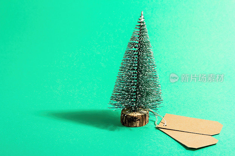 圣诞销售概念在绿松石背景。装饰冷杉树和纸标签。传统的新年标志