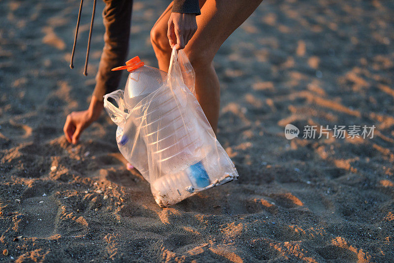 在海滩上捡塑料垃圾