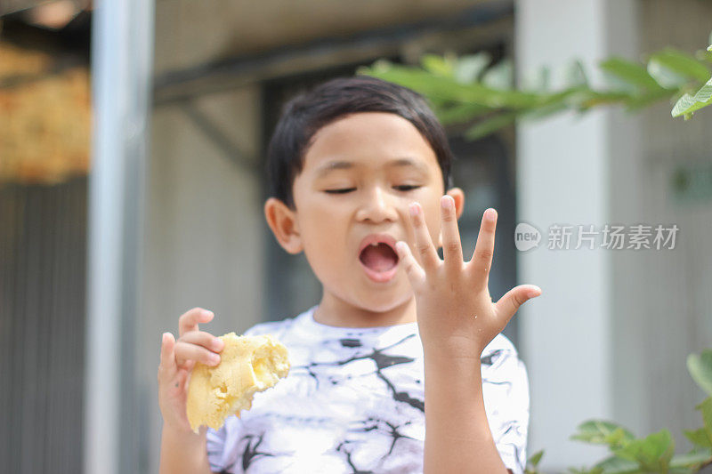 男孩站在前屋吃面包