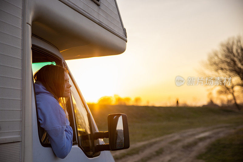 年轻女子享受日落期间露营骑