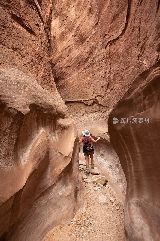 探索妇女徒步旅行槽峡谷埃斯卡兰特犹他州垂直