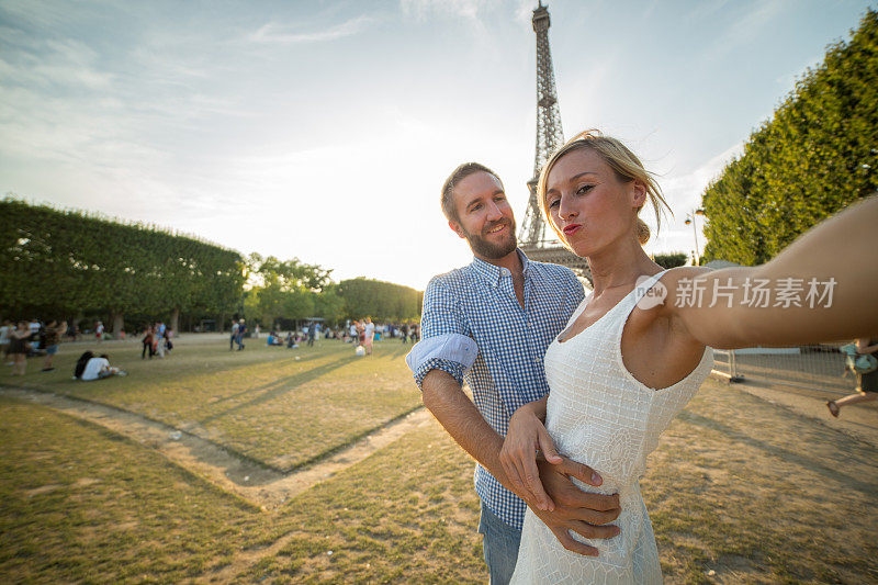 一对年轻夫妇在巴黎埃菲尔铁塔前自拍
