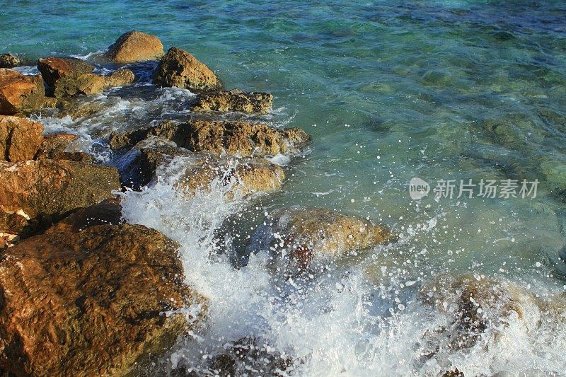 在快速快门速度下，海浪撞击海滩上的岩石