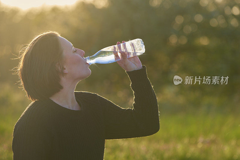 年轻女子喝着水瓶