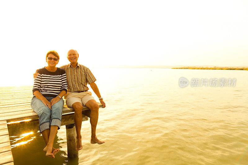 快乐微笑的退休老人坐在湖边