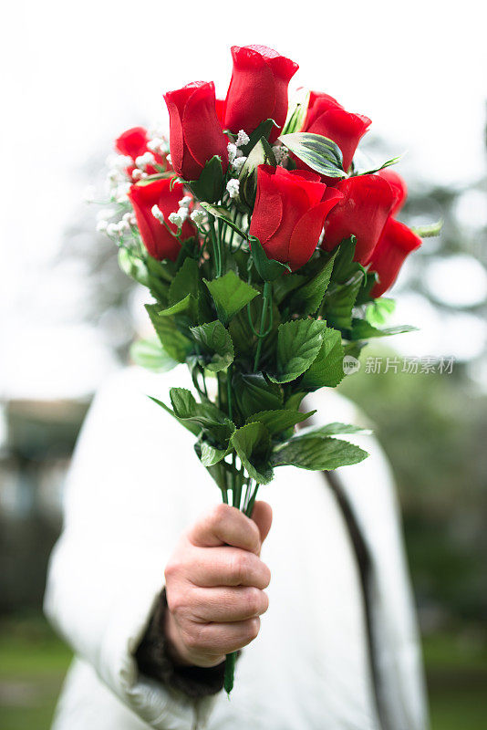 女人拿着一束玫瑰给圣瓦伦丁