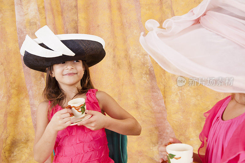 两个7尺8寸的白人小女孩，在玩茶话会帽