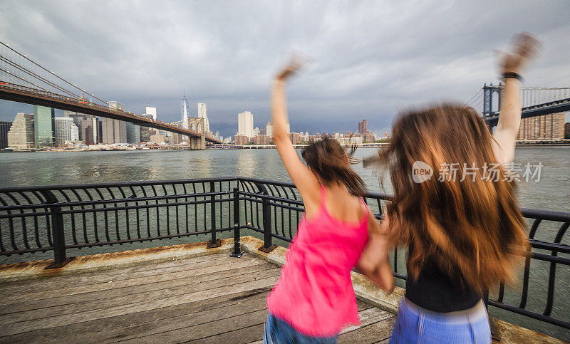 两个女孩，姐妹，在暴风雨中看着曼哈顿