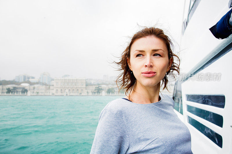 一名年轻女子在伊斯坦布尔附近的游艇上看向别处