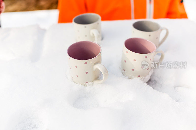 白雪覆盖的桌子上有四个空杯子