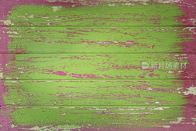 旧风化的粉红色和绿色木板背景。