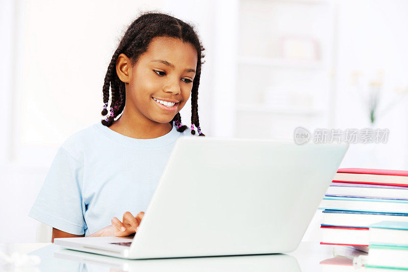 一个非裔美国女孩在用笔记本电脑