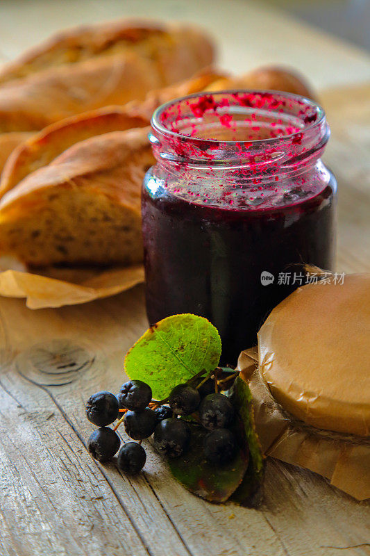 打开装着野莓果酱、新鲜浆果和面包的罐子