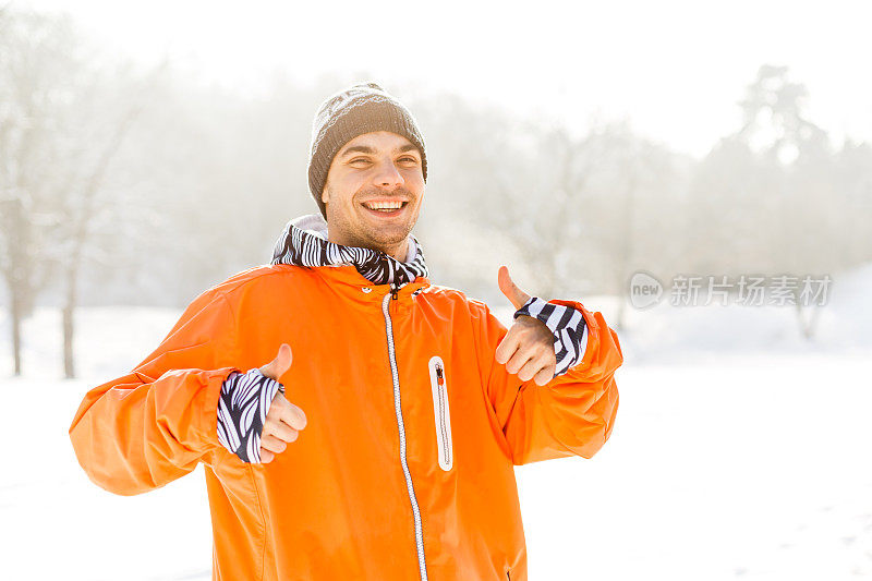 男人在雪地上竖起大拇指