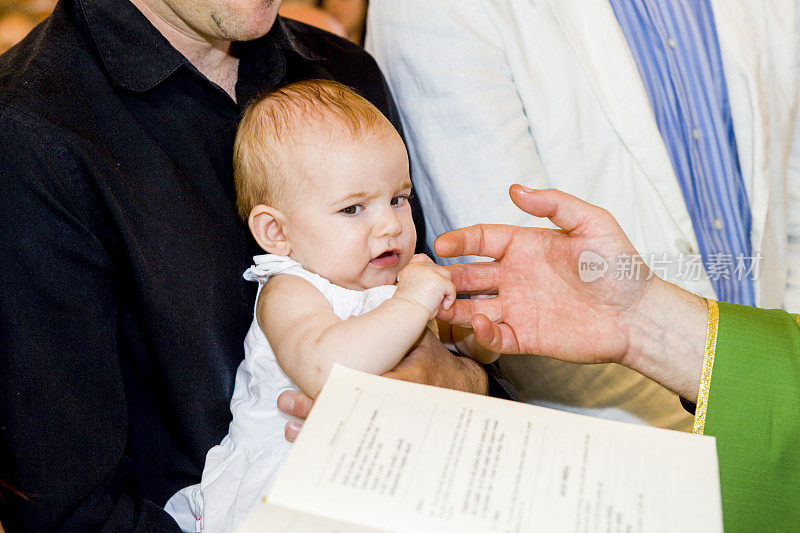 牧师正在教堂里给小婴儿洗礼。