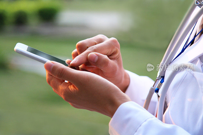 医生使用智能手机，白大褂和听诊器