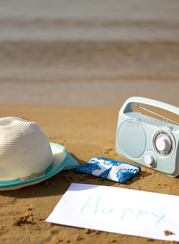 快乐:带收音机和太阳帽的海滩度假(特写)