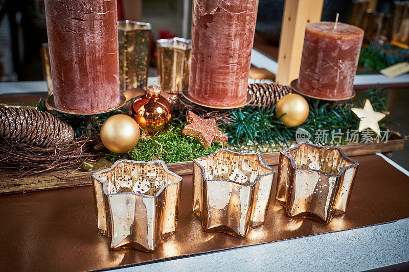 圣诞装饰，复古的样子:桌子上有三个金色的烛台，周围是烛台